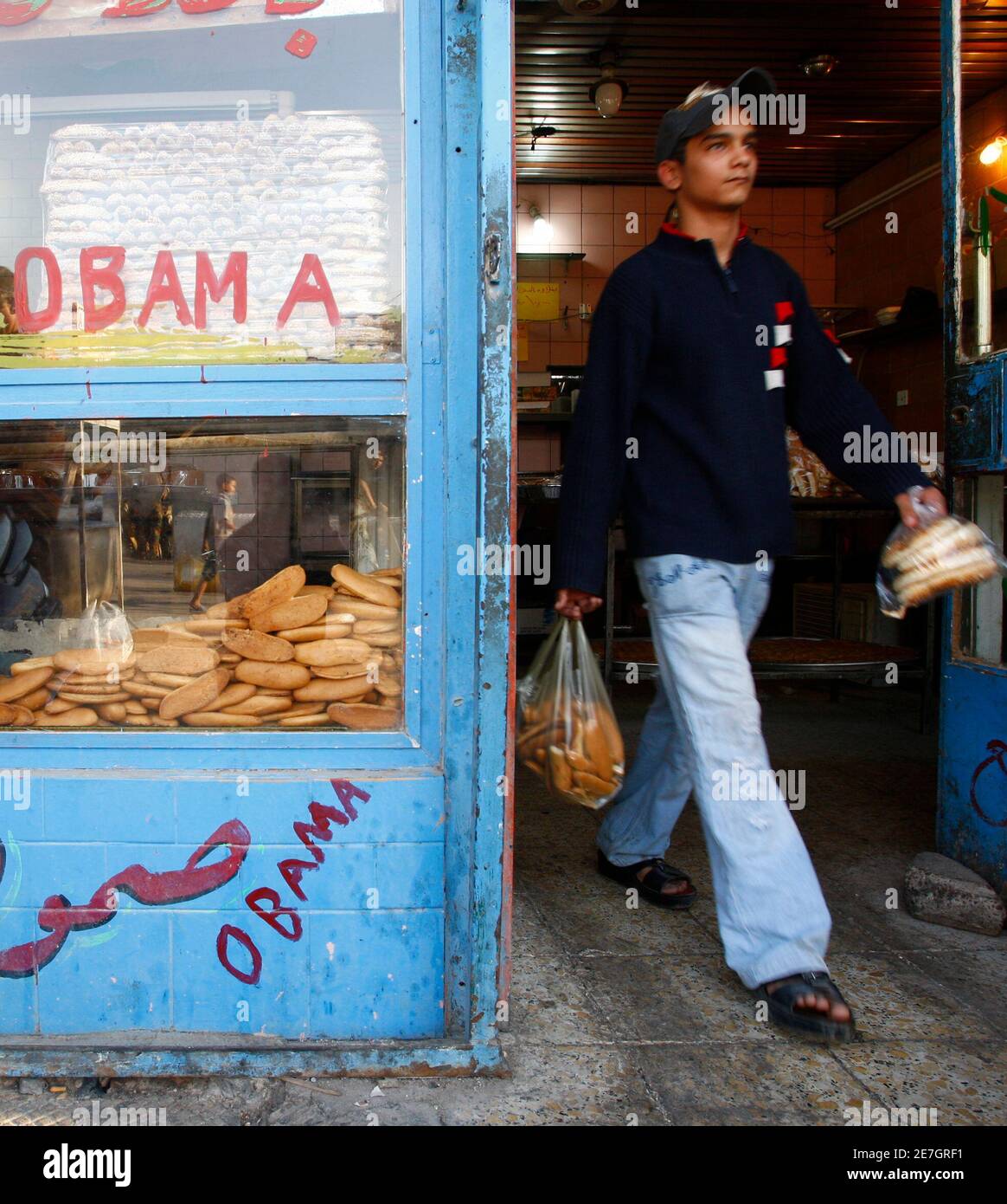 A resident leaves a bakery renamed after U.S. President-elect Barack Obama, in Baghdad November 12, 2008. Hassan Ala'uddin, the bakery owner, said he repainted the sign for his bakery to 'Obama', hoping the president-elect will bring change to the U.S and Iraq.    REUTERS/Ceerwan Aziz  (IRAQ) Stock Photo