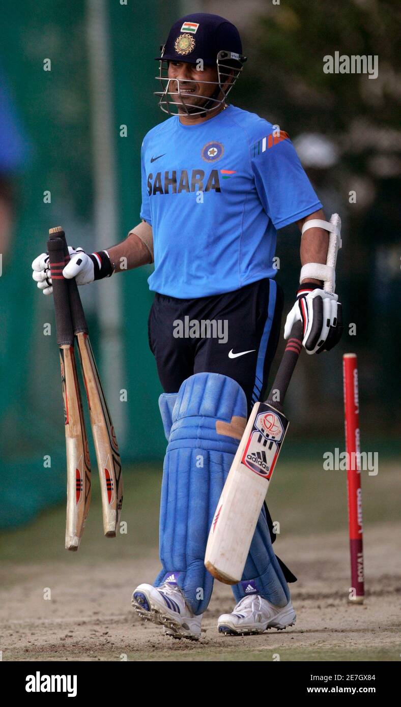 Sachin Tendulkar holds bats as he walks attending a cricket training session in southern Indian city of Hyderabad November 4, 2009. India and Australia will play their fifth one-day