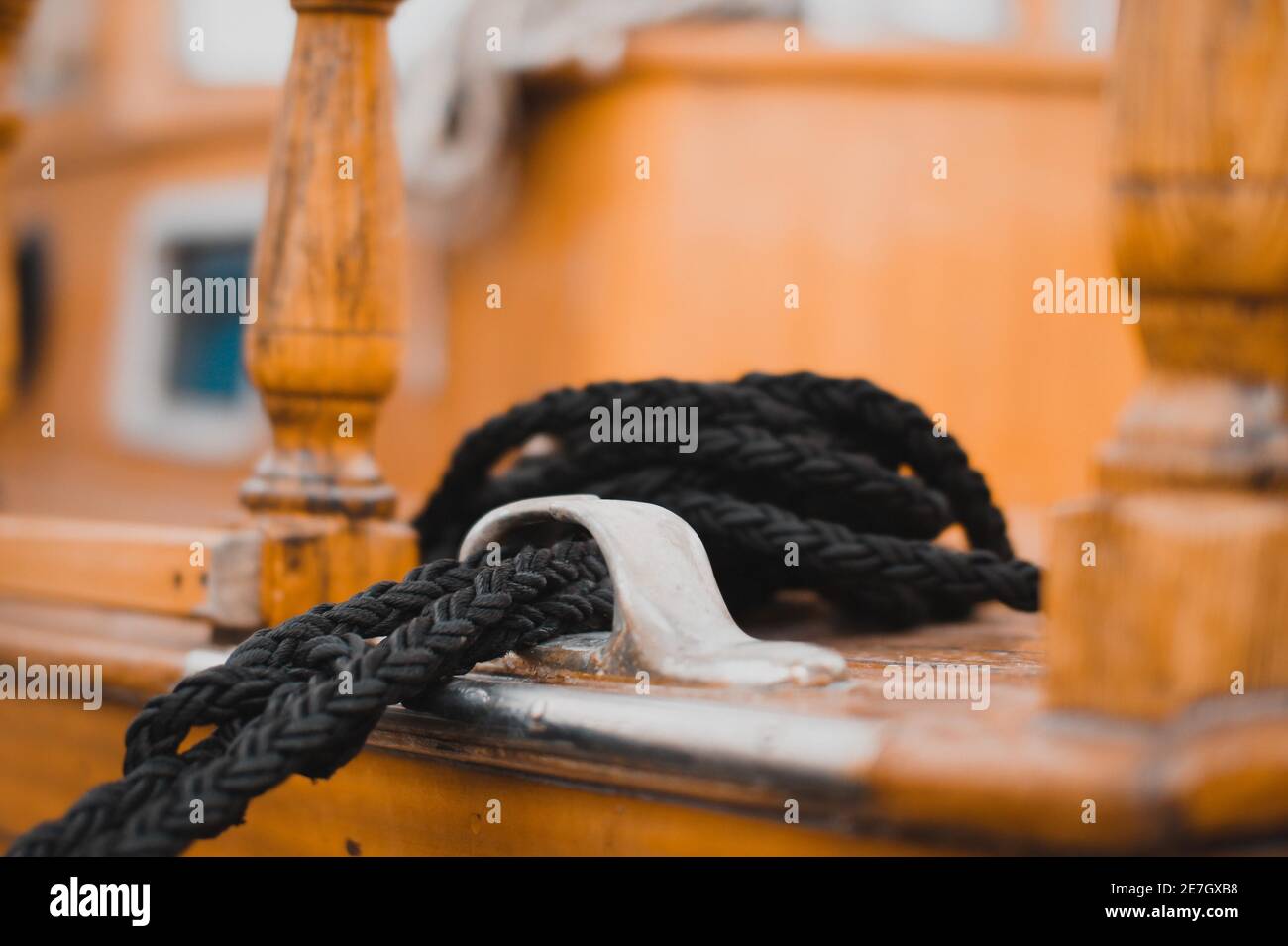 Closeup of a black-colored rope and its holder on a ship captured during the daytime Stock Photo