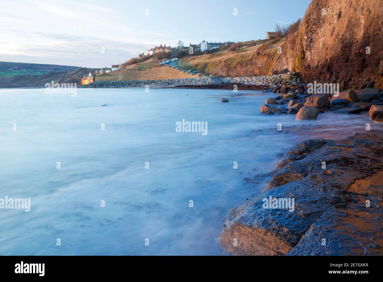 Early morning view of Robin Hood's Bay, showing sea-worn cliff errosion, rock sea defences and sea wall defences below the village itself. Stock Photo