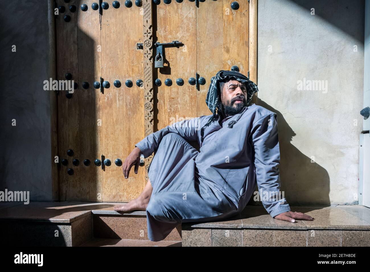 Saudi Arabian men sitting in front of the closed shop in Al Hasa, Saudi Arabia. Stock Photo