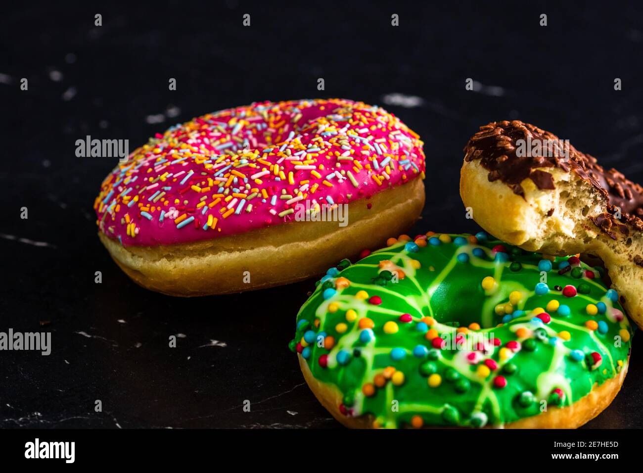 Glazed donuts with sprinkles isolated. Close up of colorful donuts ...
