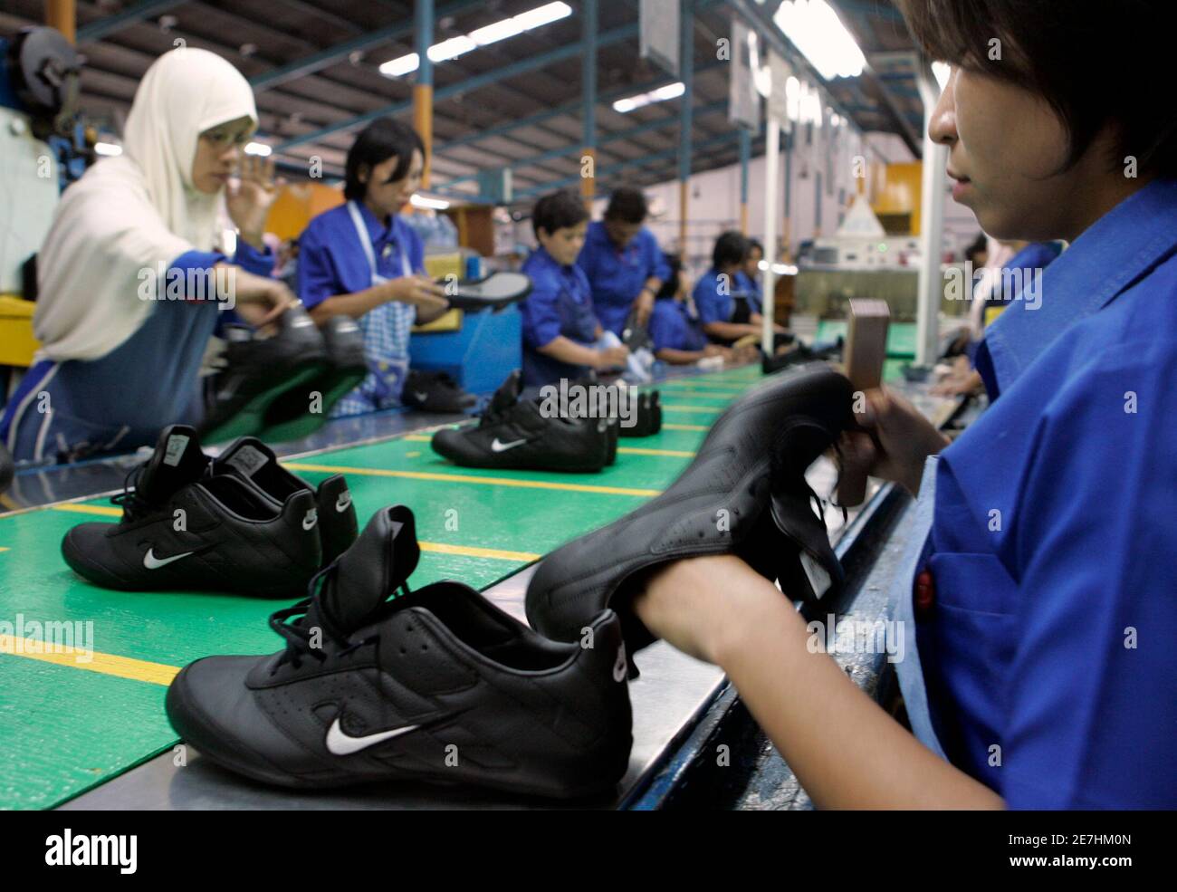 Labourers work at a Nike shoes factory in Tangerang in West Java province  August 2, 2007. U.S. sportswear maker Nike Inc. has offered to delay  severing contracts with two Indonesian shoe firms
