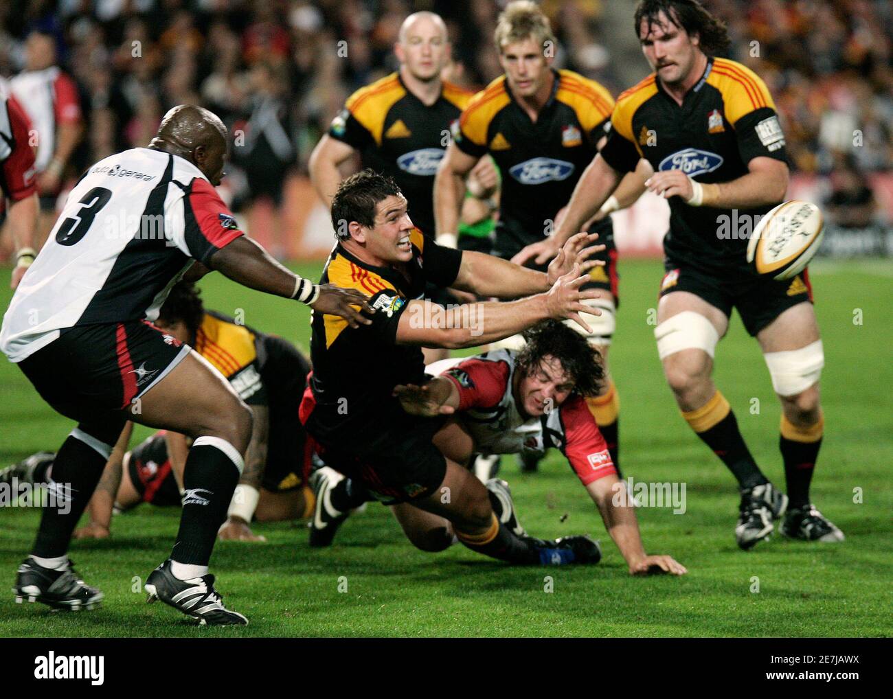 Ben May C Of New Zealand S Waikato Chiefs Flicks Out A Pass Despite The Attention Of Cobus Grobbelaar R On Ground And Lawrence Sephaka L Of South Africa S Lions During The Super