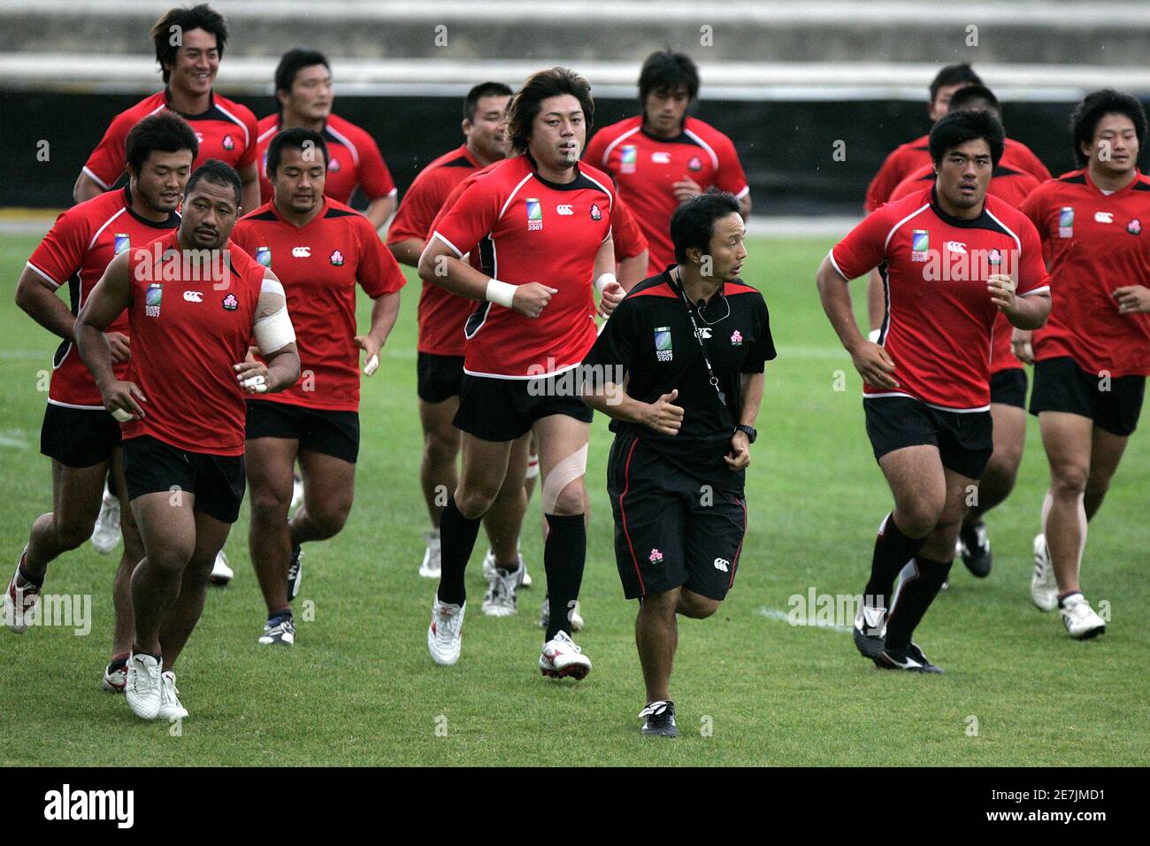 Japan rugby team players run during a training session under the rain at stadium Michel Bendichou in Colomiers, southwestern France, September 17, 2007. Japan plays in Pool B with Australia, Wales, Fiji and Canada in the Rugby World Cup 2007 REUTERS/Jean-Philippe Arles (FRANCE) Stock Photo