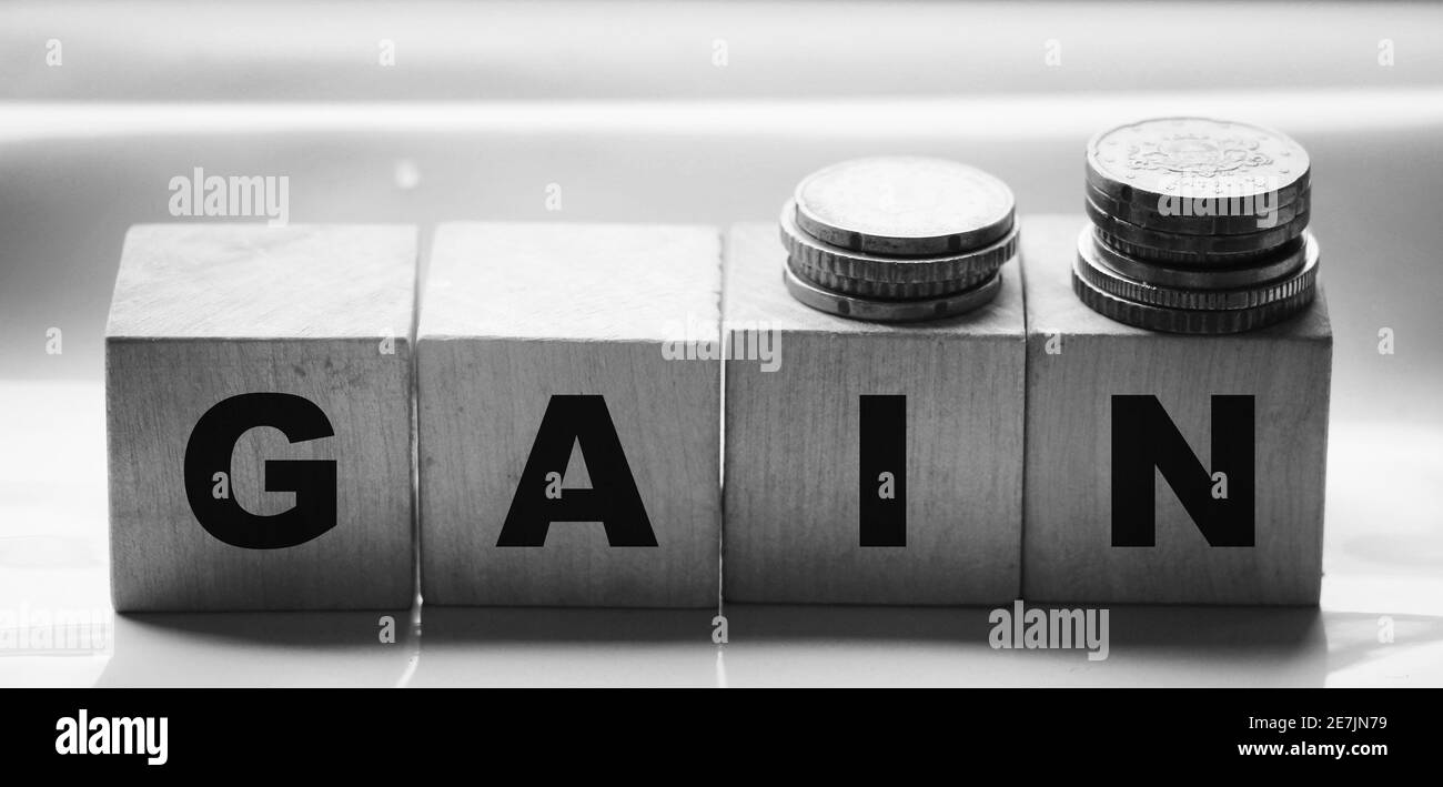 inscription gain on wooden cubes with letters oand coins. Business profit concept. Stock Photo