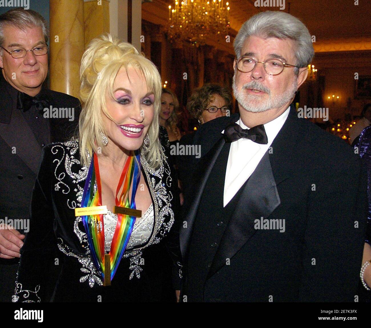 2006 Kennedy Center Honoree singer Dolly Parton (L) and film producer George Lucas walk out of the State Dining Room at the conclusion of the evening gala on December 2, 2006 in Washington.    REUTERS/Mike Theiler (United States) Stock Photo