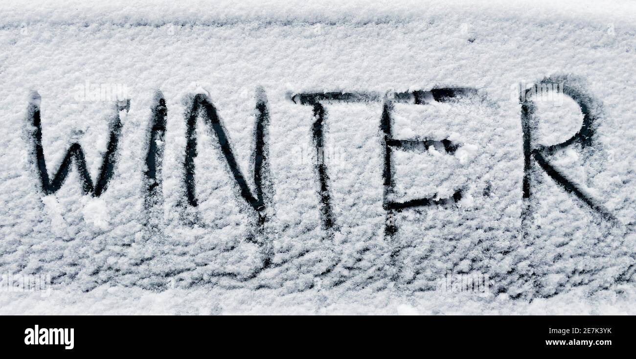 word winter written with finger in fresh snow on car window Stock Photo