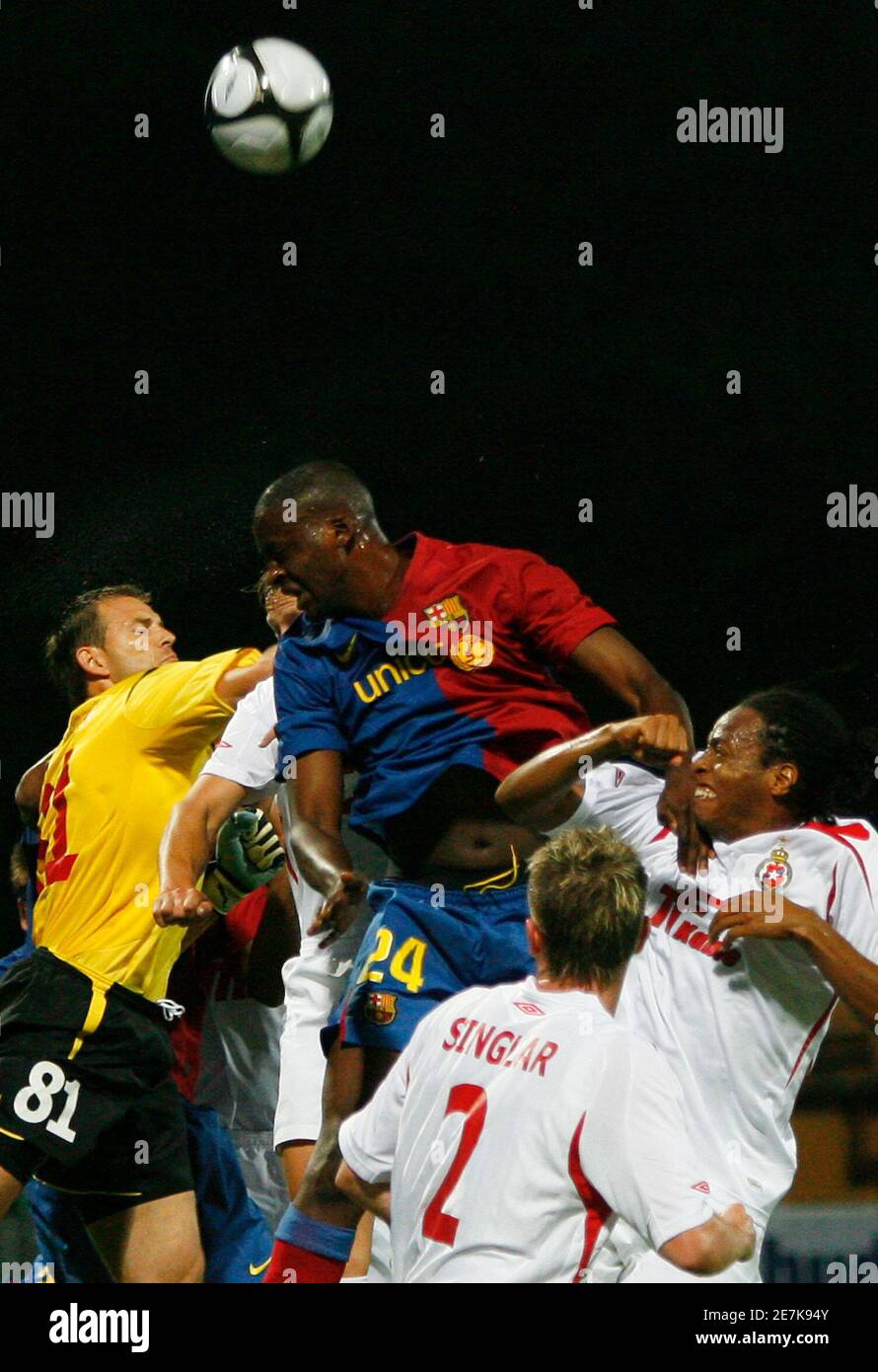 Wisla Krakow's Mariusz Pawelek (L) and Junior Diaz (R) fight for the ball  with Barcelona's Yaya Toure (C) during their Champions League third  qualifying round, second leg soccer match in Krakow August