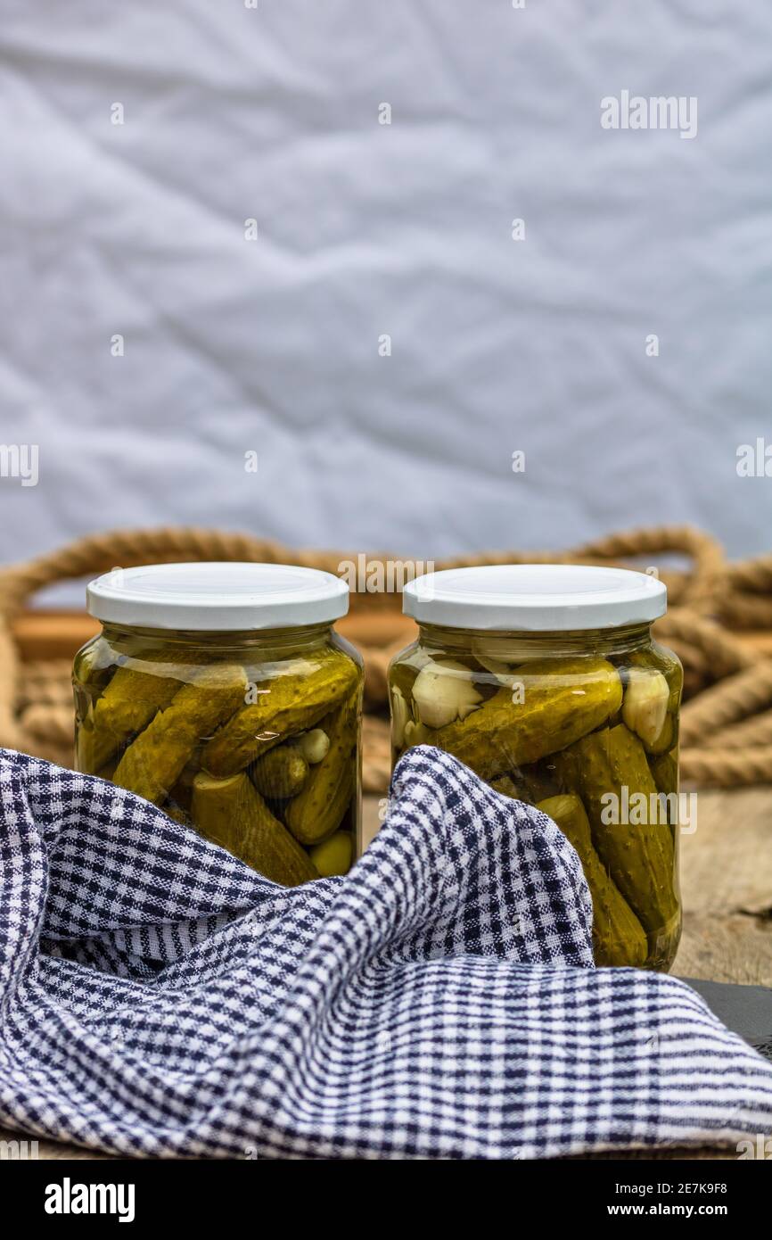 Glass jars with pickled red bell peppers and pickled cucumbers (pickles