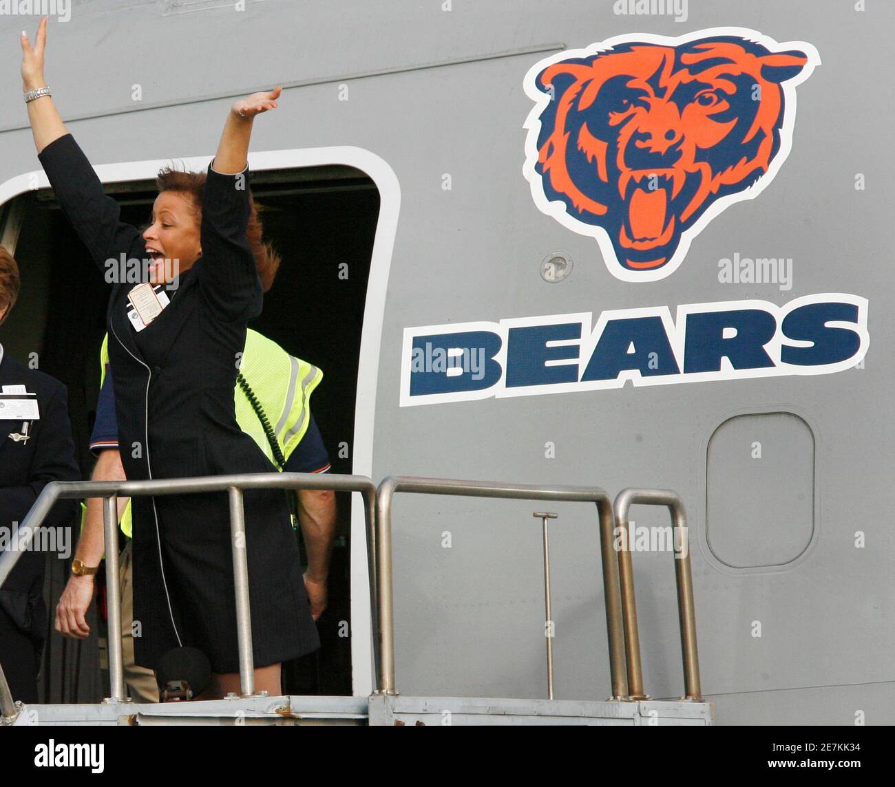 a-united-airlines-flight-attendant-waves-as-players-from-the-chicago-bears-depart-on-team-buses-after-arriving-at-miami-international-airport-january-28-2007-the-bears-will-play-in-super-bowl
