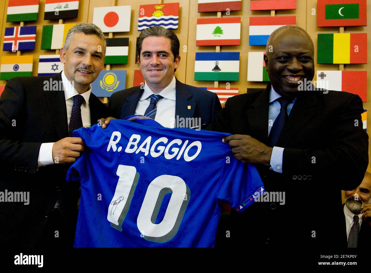 Former Italy striker Roberto Baggio (L) gifts to Jacques Diouf (R),  Director-General of Food and Agriculture Organization of the United Nations  (FAO), his Italy's soccer jersey as E.Macedo de Medeiros, Chief Executive