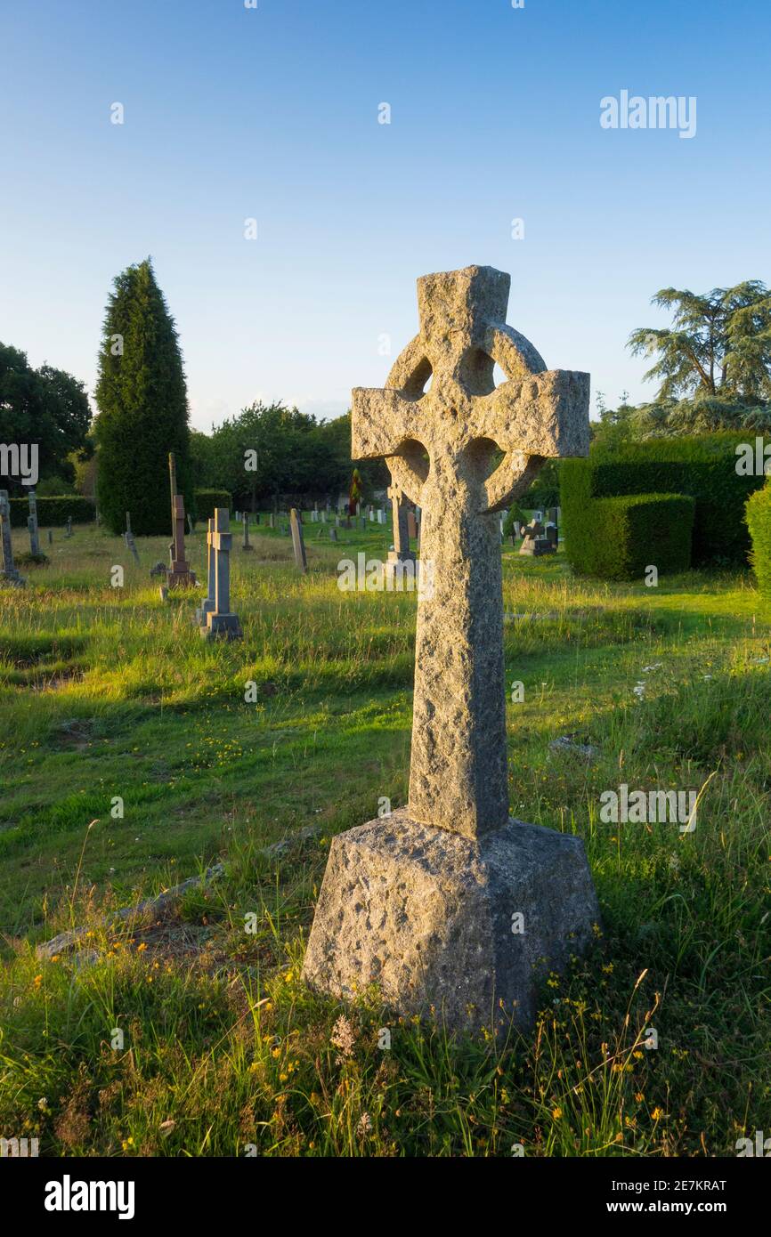 Celtic cross gravestone and wildflowers, Walstead cemetary, Lindfield, West Sussex, UK. Stock Photo