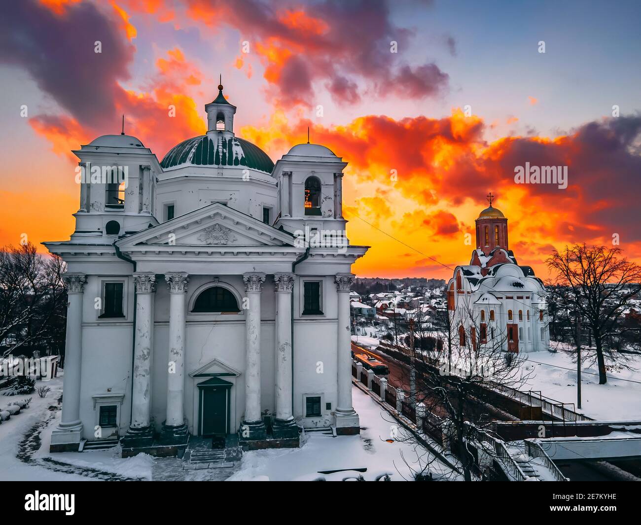 Aerial view of the cathedral and church in snow-covered small european city at bright winter sunset Gorgeous sunset and clouds.. Drone. Winter. Ukrain Stock Photo