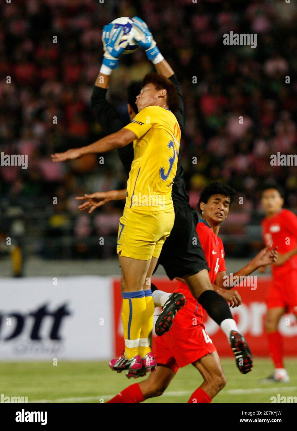 Thailand S Kirati Kaewsombut Yellow Fights For The Ball With Singapore S Goalkeeper Hassan Sunny During Their Thailand King S Cup Football Tournament At His Majesty The 80th Birthday Anniversary Stadium In Nakhon Ratchasima Province