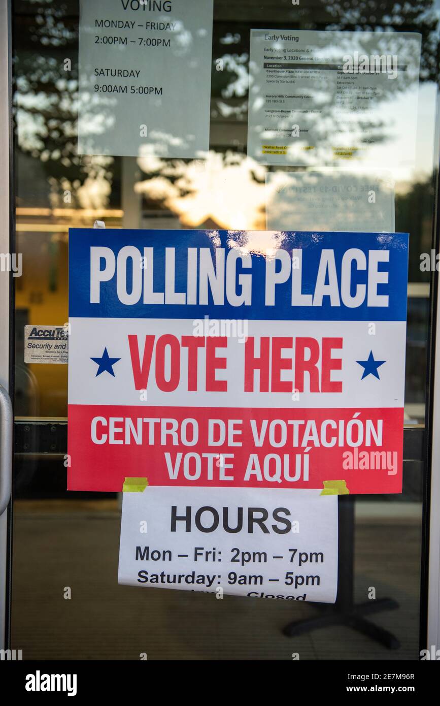 A red, white and blue sign reads 'polling station, vote here' in both English and Spanish at a polling station in Arlington, Virginia. Stock Photo
