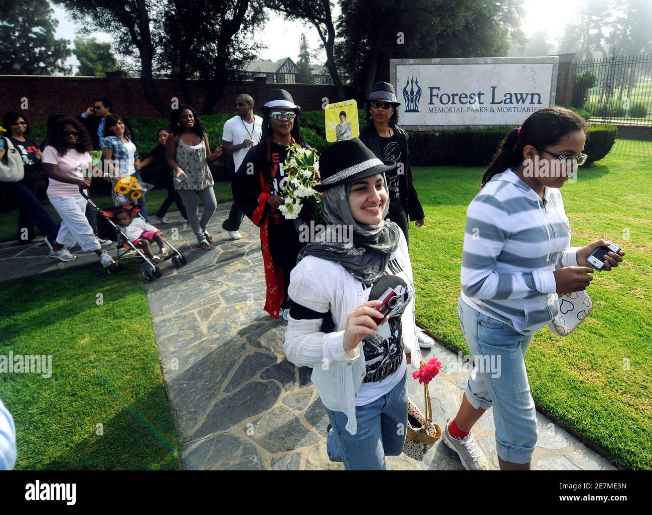 The first group of fans walk after being allowed in to pay tribute to the late pop star Michael Jackson a year after his death at his grave site at Forest Lawn Memorial Parks and Mortuaries in Glendale, California June 25, 2010. Jackson's sudden death at age 50 on June 25 last year in Los Angeles sparked an outpouring of grief internationally for the former child star, who was rehearsing for a series of concerts aimed at reviving a career shattered by bizarre events as an adult and acquittal on charges of molesting a 13-year-old boy.     To match Reuters Life! PEOPLE-JACKSON/    REUTERS/Gus Ru Stock Photo