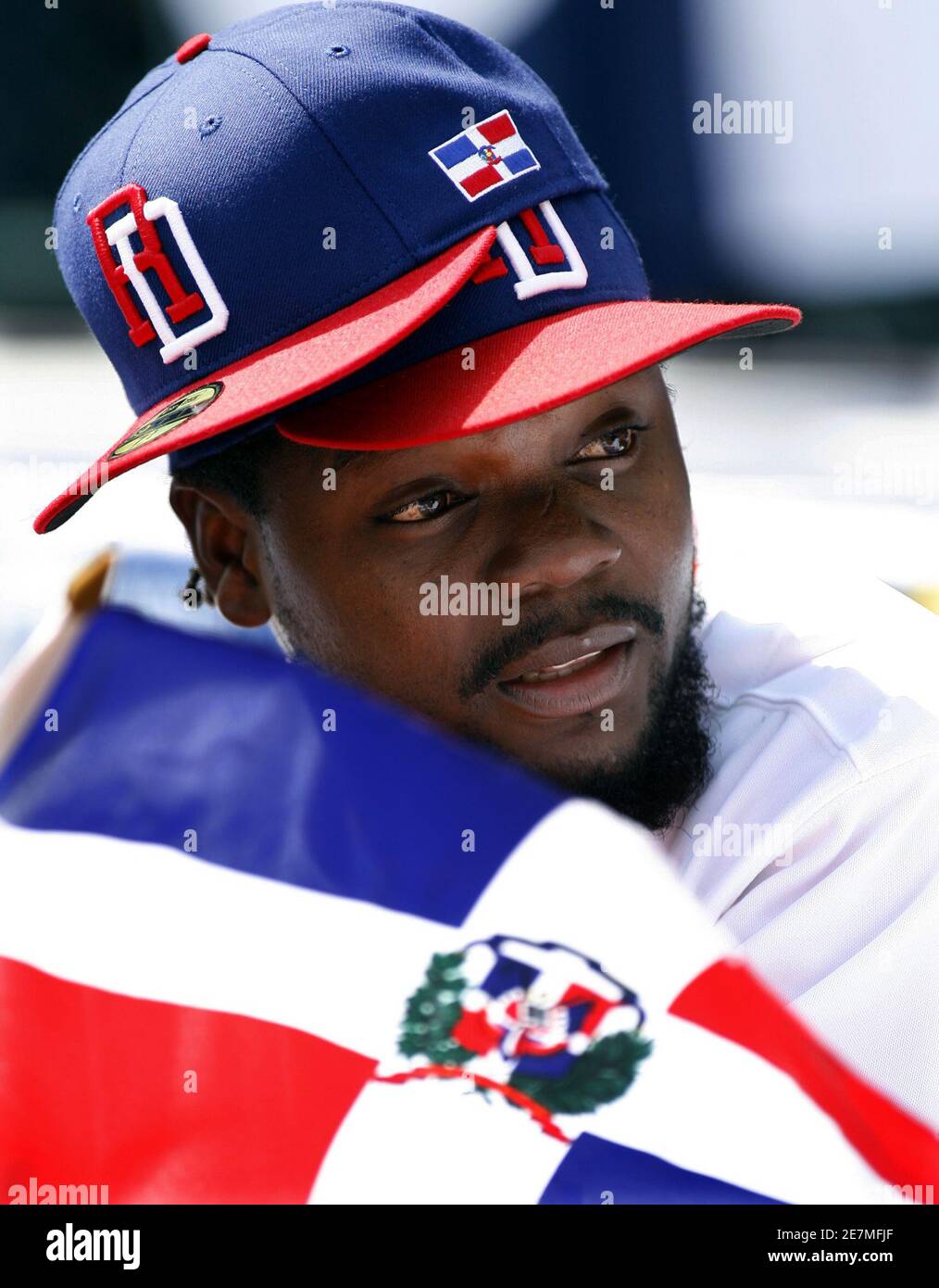 Dominican Republic player Fernando Rodney wears two hats and holds a  Dominican Republic flag as he takes part in pre-game ceremonies before  their team faced Italy in their World Baseball Classic first