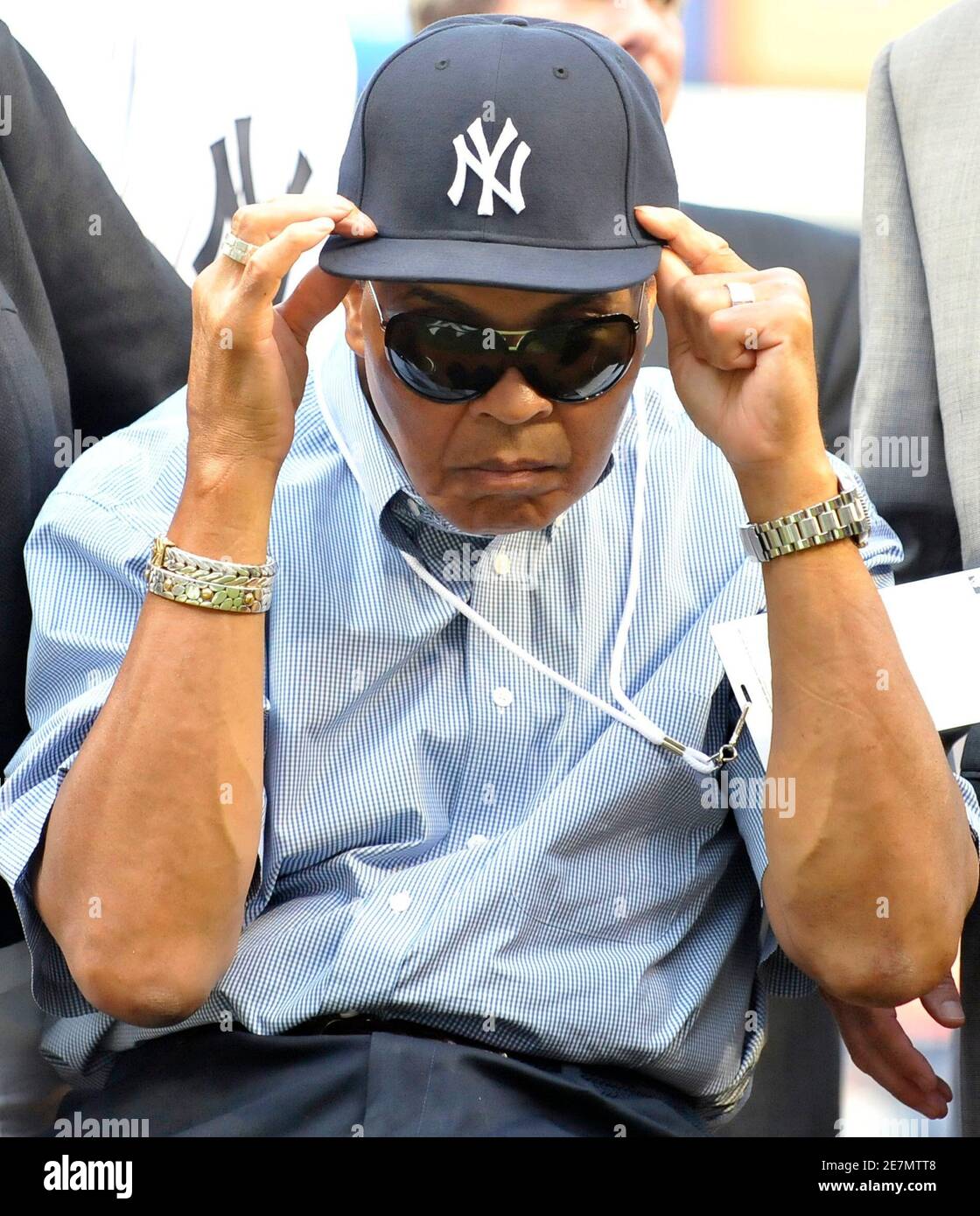 Boxing great Muhammad Ali adjusts a New York Yankees cap given to him by Yankees  captain Derek Jeter during an appearance by Ali on the field before the  Yankees' MLB American League