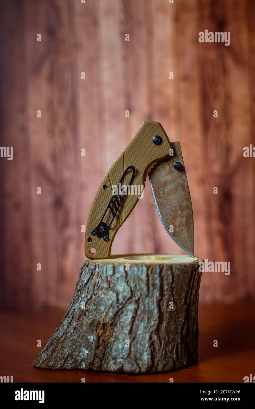 folding hunting knife on wood on brown background Stock Photo