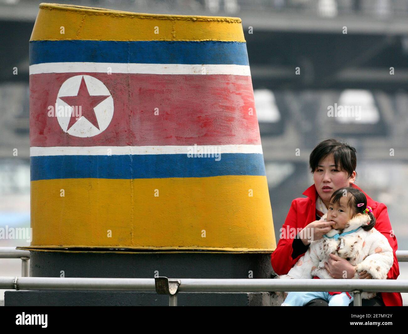 A North Korean woman feeds a baby while touring on a boat to celebrate May Day in the Yalu River near the Chinese border city of Dandong May 1, 2010. REUTERS/Jacky Chen (CHINA - Tags: SOCIETY TRAVEL BUSINESS EMPLOYMENT) Stock Photo