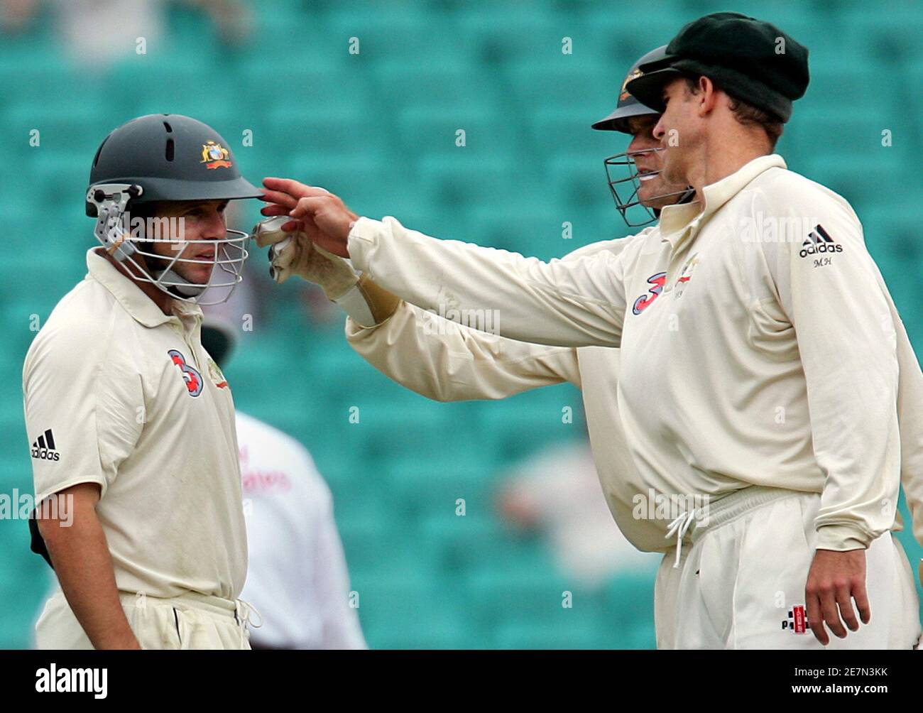 Australia's Matthew Hayden (R) and Adam Gilchrist (2nd R) inspect the  helmet of Brad Hodge after he was struck in the head while fielding at  short leg during the fifth day's play