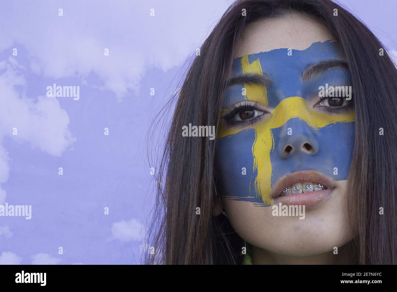 Flag of Sweden painted on a face of a young female Stock Photo