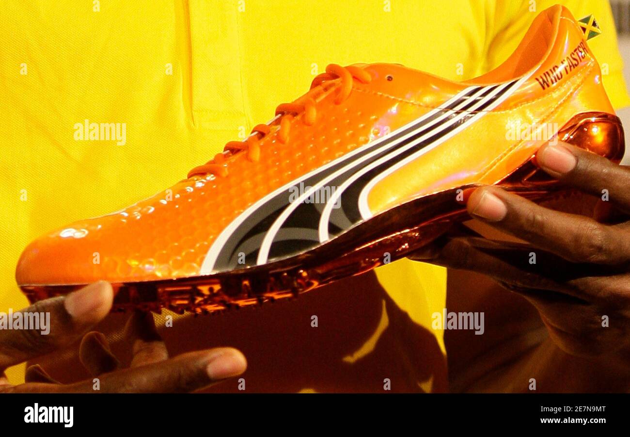 Sprinter Usain Bolt of Jamaica holds a Puma shoe during a news conference  in Berlin, August 13, 2009. Bolt is to compete in the IAAF World  Championships in Athletics that will take