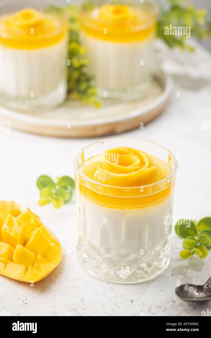 Italian dessert panna cotta with mango in glass on white background ...