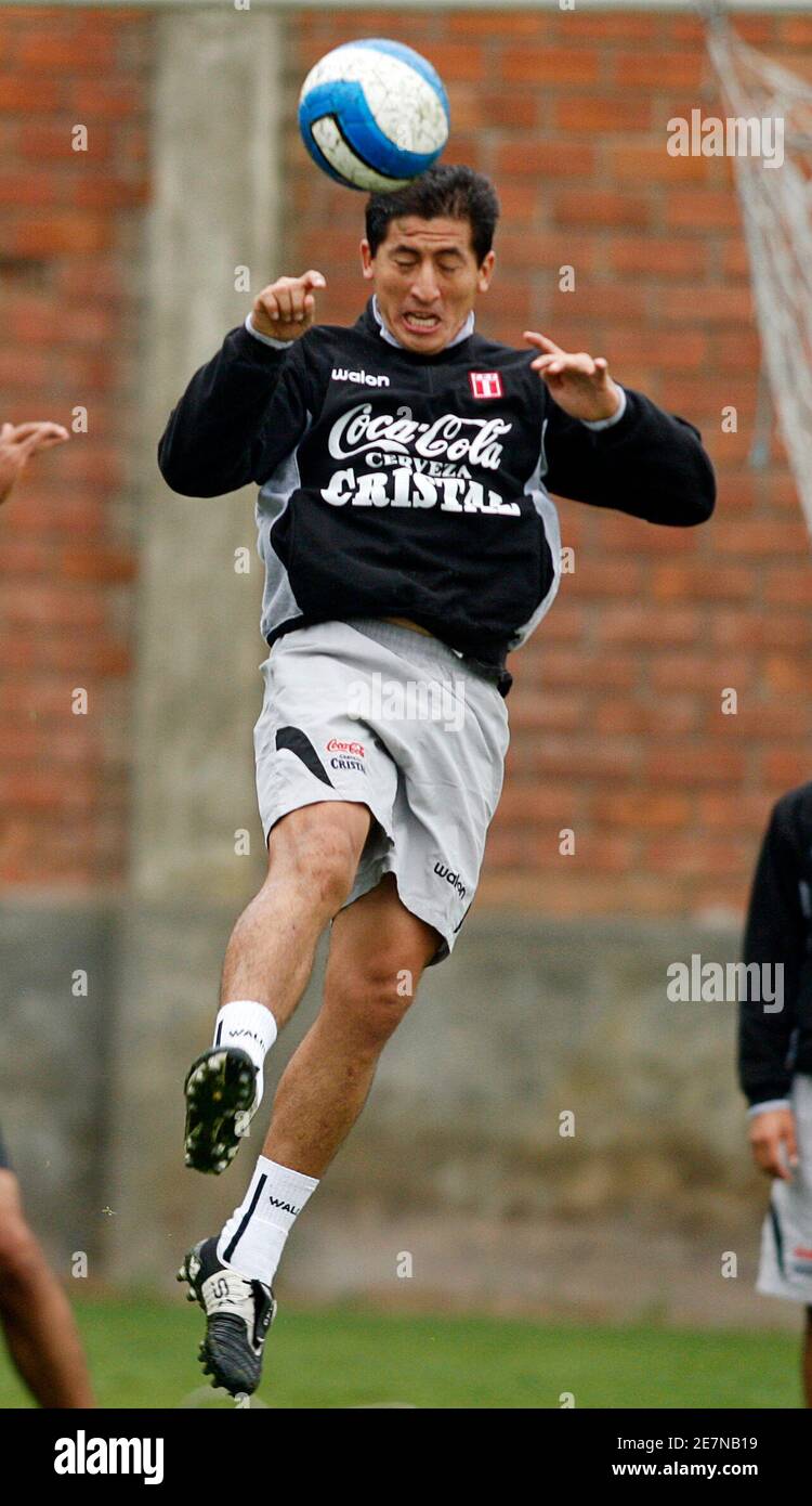 Peru's soccer player Johan Fano heads the ball as coach Jose Del Solar  directs the training session in Lima June 3, 2009. Peru will face Ecuador  in a 2010 World Cup qualifying