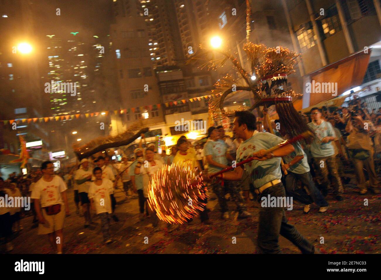 Participants manoeuvre a 'fire dragon' made of straw and covered with incense sticks during Mid-Autumn festival celebrations at Hong Kong's Tai Hang district October 2, 2009. The Mid-Autumn festival is on Saturday.  REUTERS/Tyrone Siu    (CHINA SOCIETY) Stock Photo