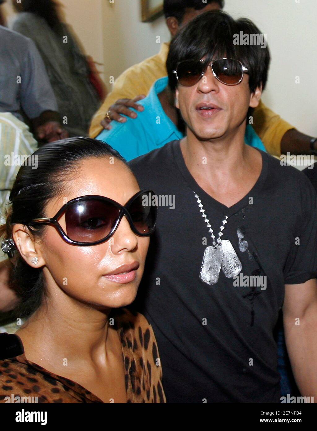 Bollywood actor Shah Rukh Khan (R) arrives with his wife Gauri at the Indian Premier League's (IPL) player auction in Mumbai February 20, 2008. The tycoons behind India's new Twenty20 cricket tournament gathered in a Mumbai hotel conference room on Wednesday ready to hammer their cheque-books to sign some of the biggest names in sport. REUTERS/Punit Paranjpe (INDIA) Stock Photo