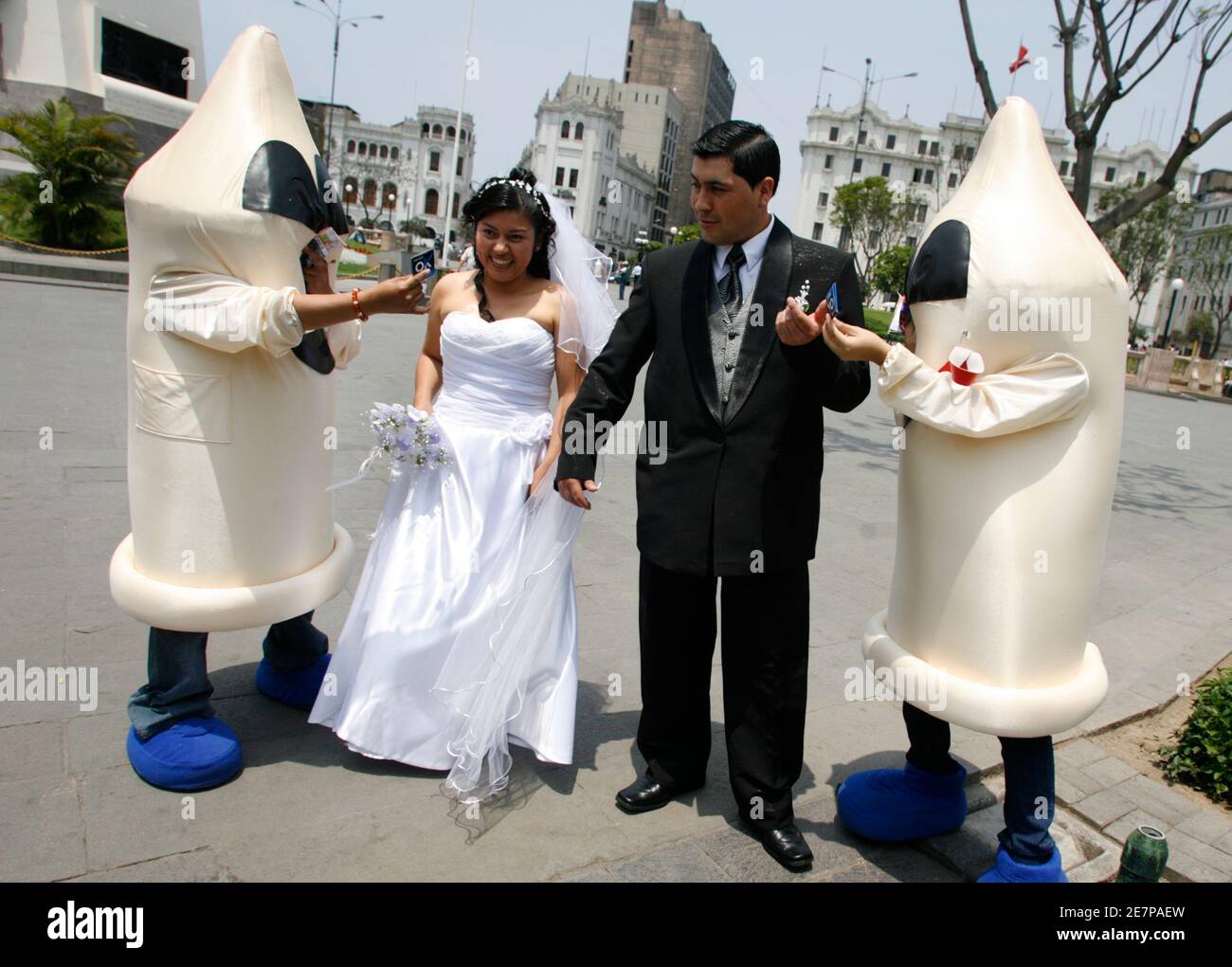 A recently married couple receives condoms from people dressed as condoms  during an AIDS and HIV prevention campaign at the square in downtown Lima  November 28, 2008. The annual World AIDS Day