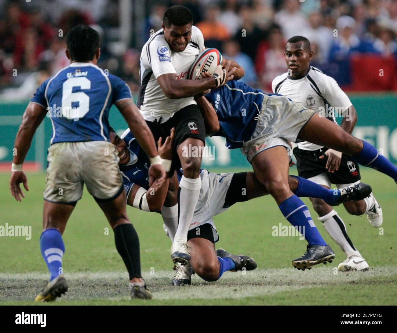 Fiji's Etonia Naba (C) is tackled by Samoa's Ofisa Treviranus (R) during the Cup final of the Hong Kong Sevens rugby tournament in Hong Kong April 1, 2007.   REUTERS/Paul Yeung  (CHINA) Stock Photo
