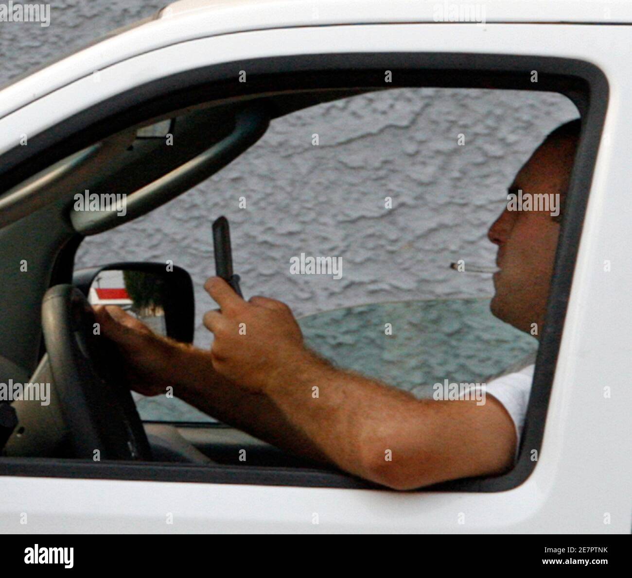 A man uses a cell phone while driving in Burbank, California June 25, 2008. California has a new law which goes into effect July 1 that requires drivers to use a hands-free device while talking on cell phones while driving or face a fine. Picture taken June 25, 2008. To match feature CALIFORNIA-CELLPHONES/  REUTERS/Fred Prouser (UNITED STATES) Stock Photo