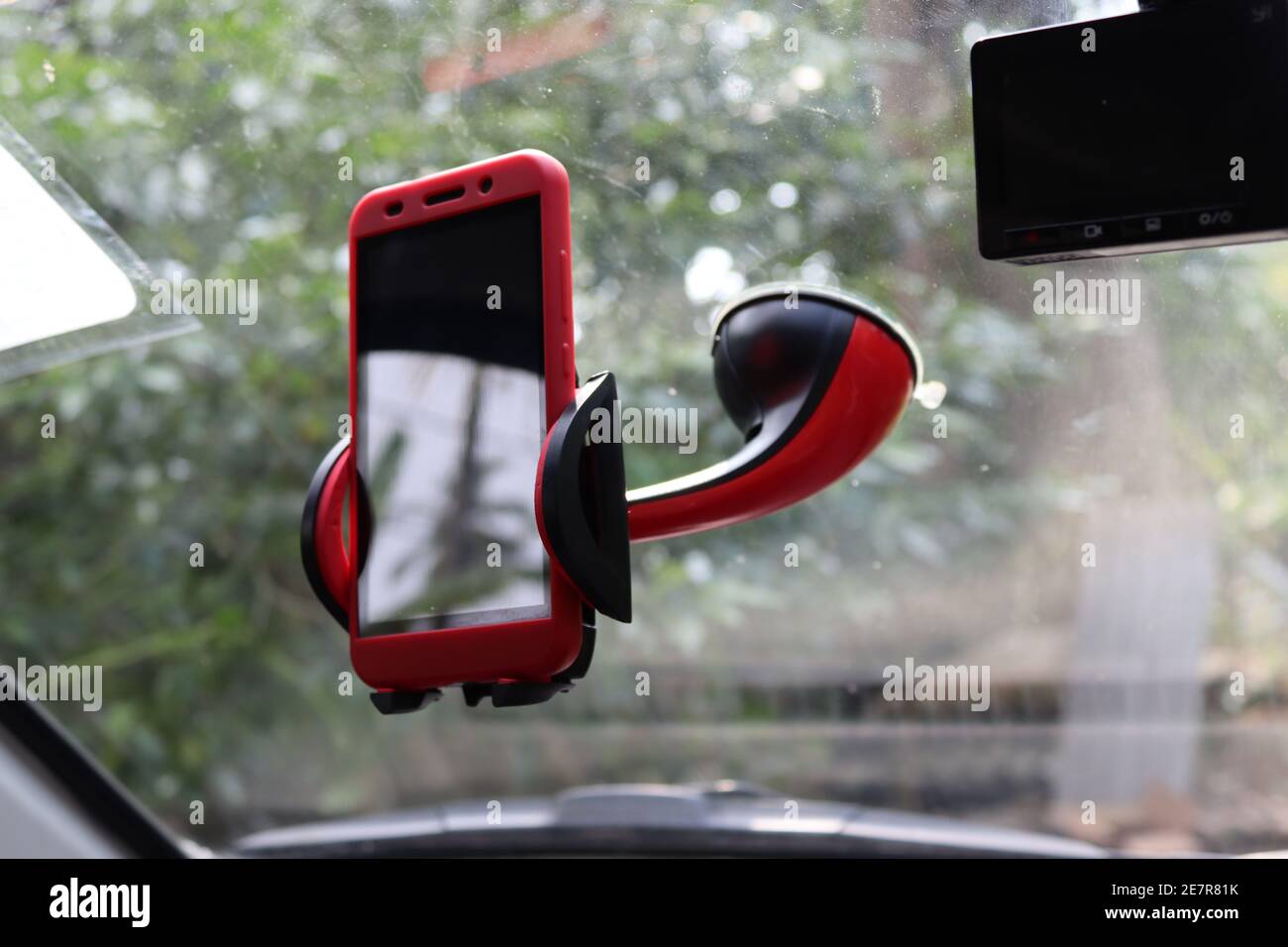 A mobile phone with a phone holder in red, in a car. Stock Photo