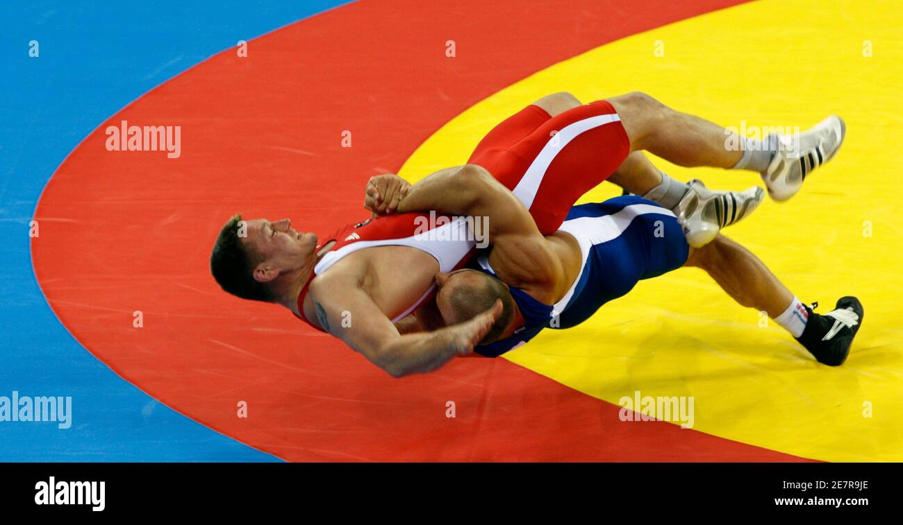 Aslanbek Khushtov of Russia (in blue) fights Mirko Englich of Germany at the men's 96kg Greco-Roman gold medal wrestling competition at the Beijing 2008 Olympic Games August 14, 2008.     REUTERS/Oleg Popov (CHINA) Stock Photo
