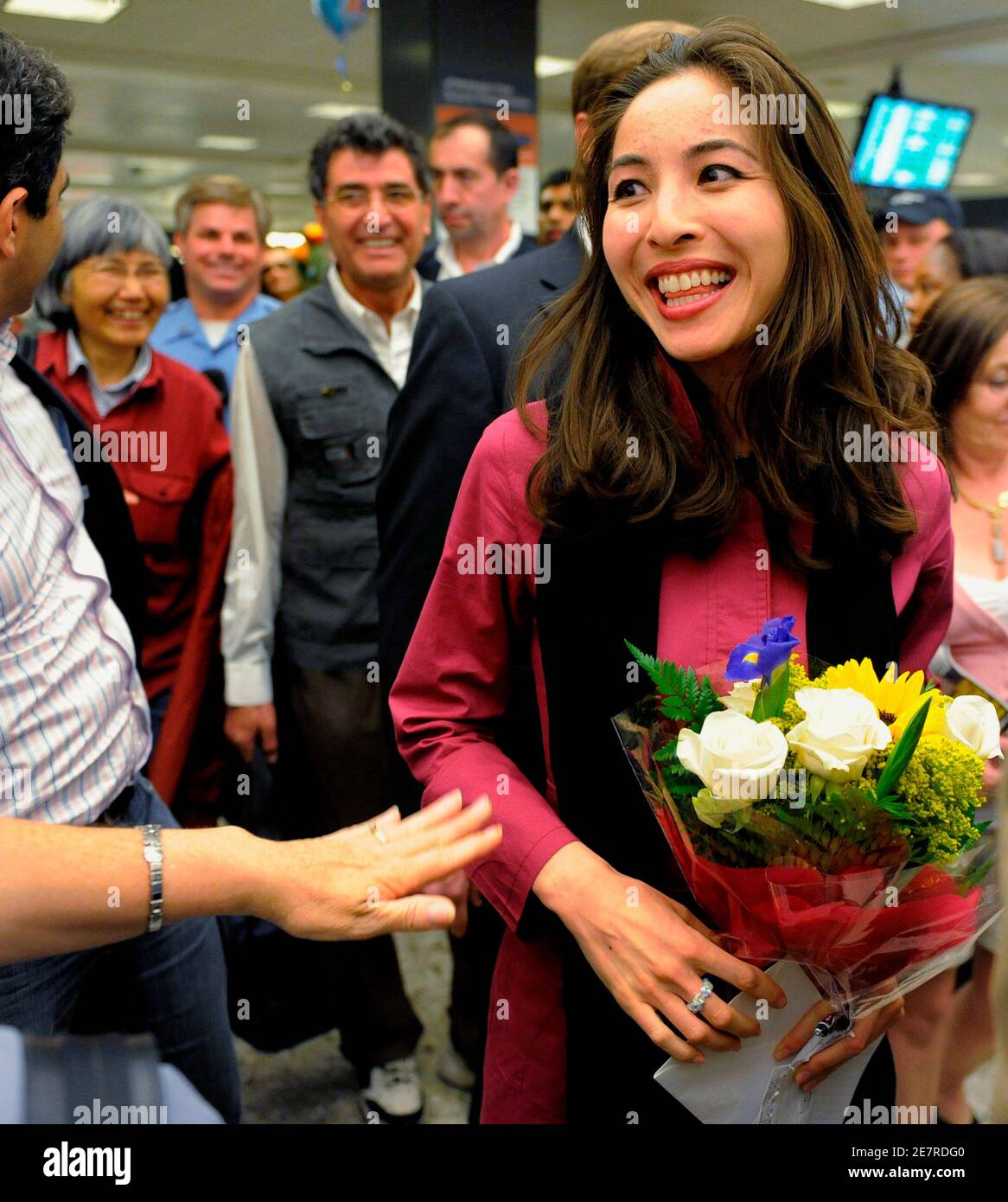 American-born journalist Roxana Saberi, who was jailed for four months by Iran on charges of espionage and later released, is greeted by flowers as she arrives at Washington Dulles International Airport, Chantilly, Virginia, May 22, 2009. Her Iranian-born father, Reza, is in rear with gray vest and her mother, Akiko, is behind him.  REUTERS/Mike Theiler (UNITED STATES) Stock Photo