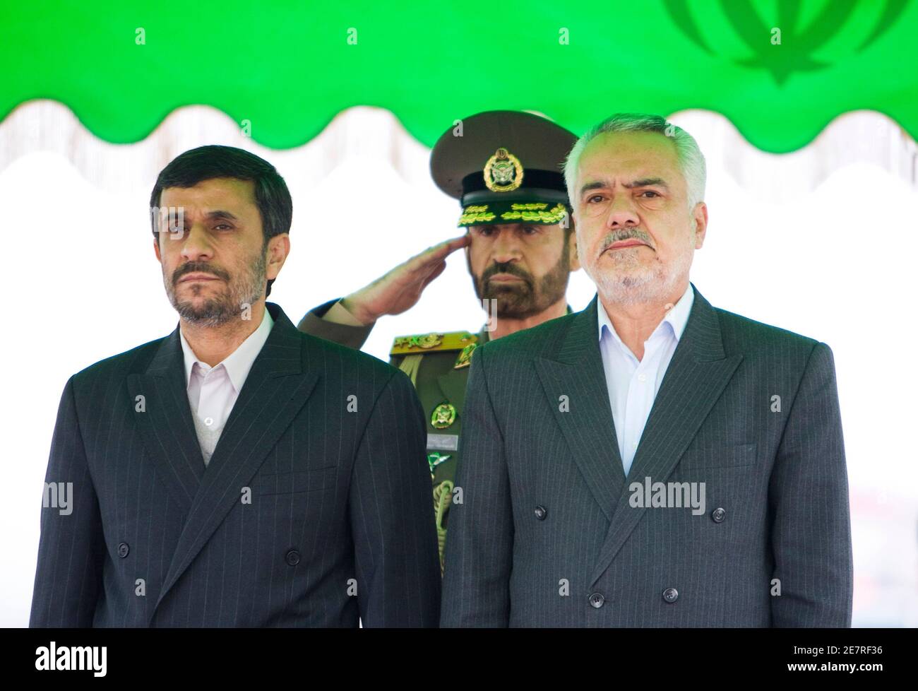 EDITORS' NOTE: Reuters and other foreign media are subject to Iranian restrictions on their ability to film or take pictures in Tehran.   Iran's President Mahmoud Ahmadinejad (L) and Iranian First Vice President Mohammad Reza Rahimi (R) stand at attention during the playing of the national anthem before Ahmadinejad leaves for Denmark at the International Mehrabad Airport in Tehran December 17, 2009. Ahmadinejad will address the U.N. climate summit in Copenhagen.   REUTERS/Raheb Homavandi (IRAN - Tags: POLITICS ENVIRONMENT) Stock Photo