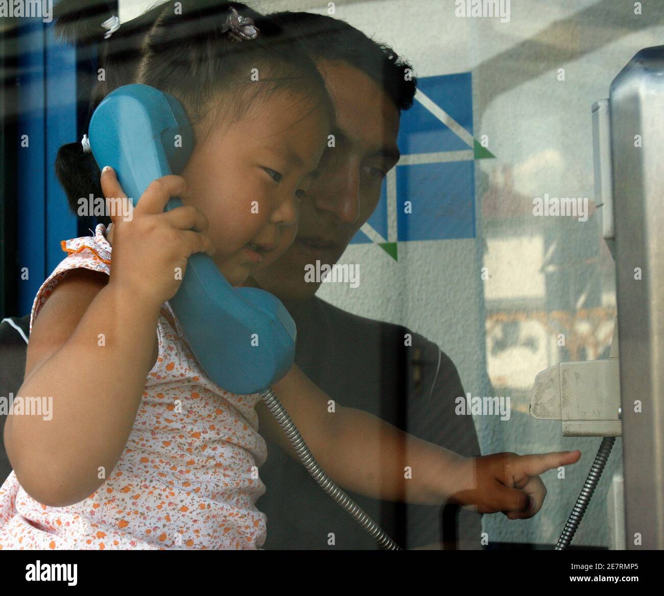 A Mongolian refugee girl uses a public phone with her relative at the Reception Centre for Asylum Seekers in Bekescsaba, 220 km (137 miles) southeast of Budapest, June 4, 2007. Hungary will join the European Union Schengen border patrol agreement on January 1, 2008, and will become EU's primary border for refugee control. The Schengen regime allows free movement of people within the EU, without border controls, and creates a unified external frontier, where police, customs and health checks are rigorous. The Word Refugee Day will held on June 20. REUTERS/Laszlo Balogh (HUNGARY) Stock Photo