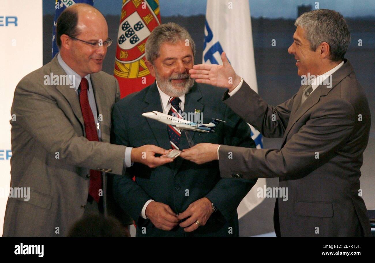 Portugal's Prime Minister Jose Socrates (R) shakes hands with Brazil's Embraer President Frederico Curado as Brazil's President Luiz Inacio Lula da Silva (C) watches after a cooperation agreement in Lisbon July 26, 2008.  Brazil's Embraer, the world's third-biggest commercial jet maker, said on Saturday it would invest 148 million euros in two components plants in Portugal to expand its operation in Europe, now mainly focused on aircraft servicing. REUTERS/Nacho Doce (PORTUGAL) Stock Photo