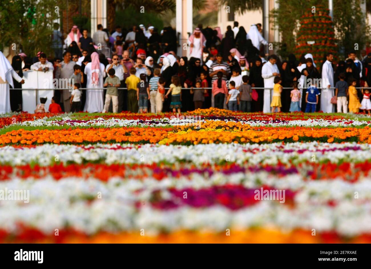 Families walk around Saudi King Abdullah's road, decorated with flowers