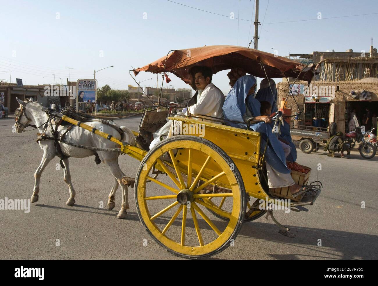 Passengers ride in a horse-drawn carriage in Herat, western Afghanistan August 11, 2009. REUTERS/Raheb Homavandi (AFGHANISTAN SOCIETY) Stock Photo