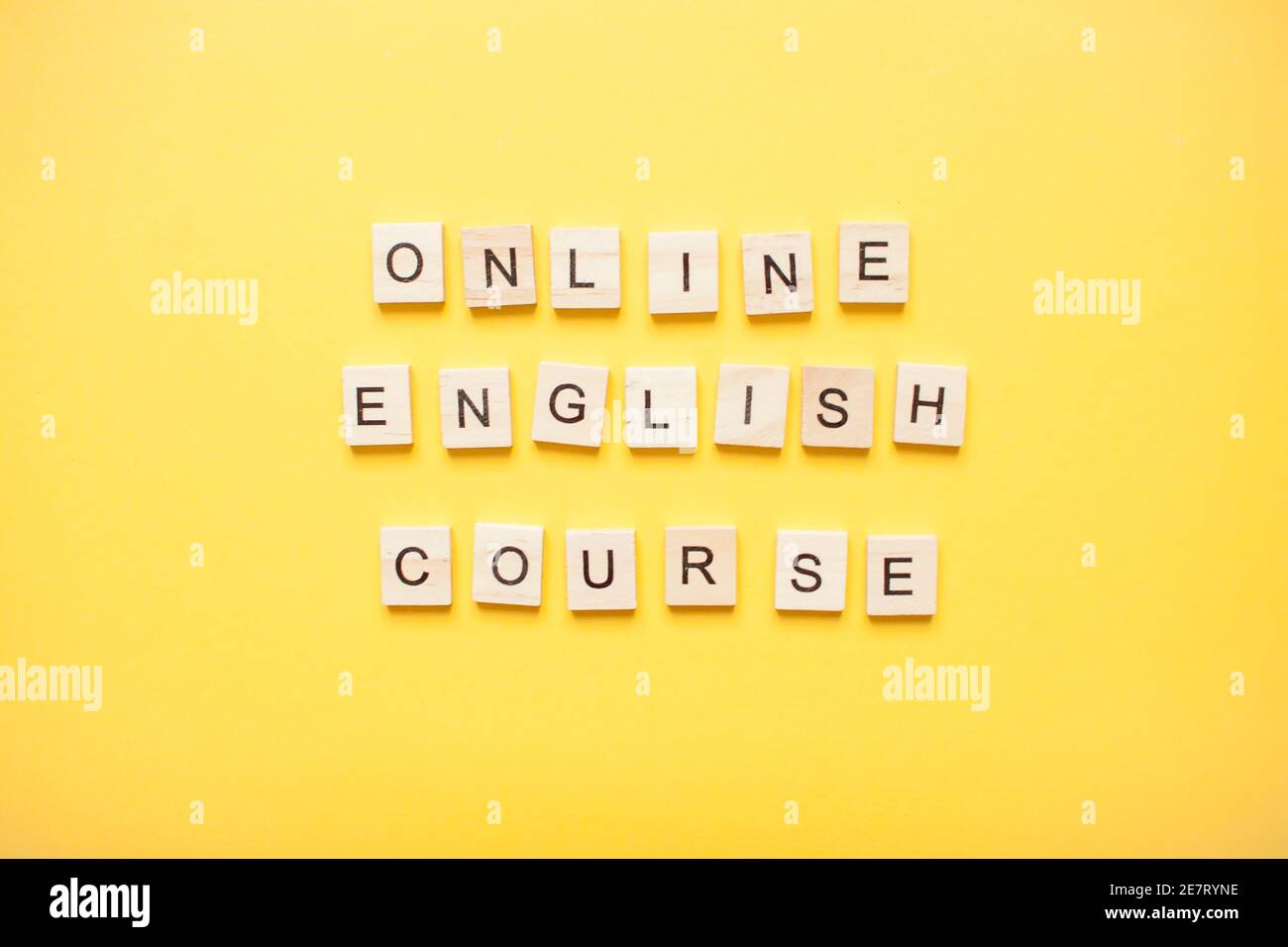 Phrase online english course made from wooden blocks on a light yellow background Stock Photo