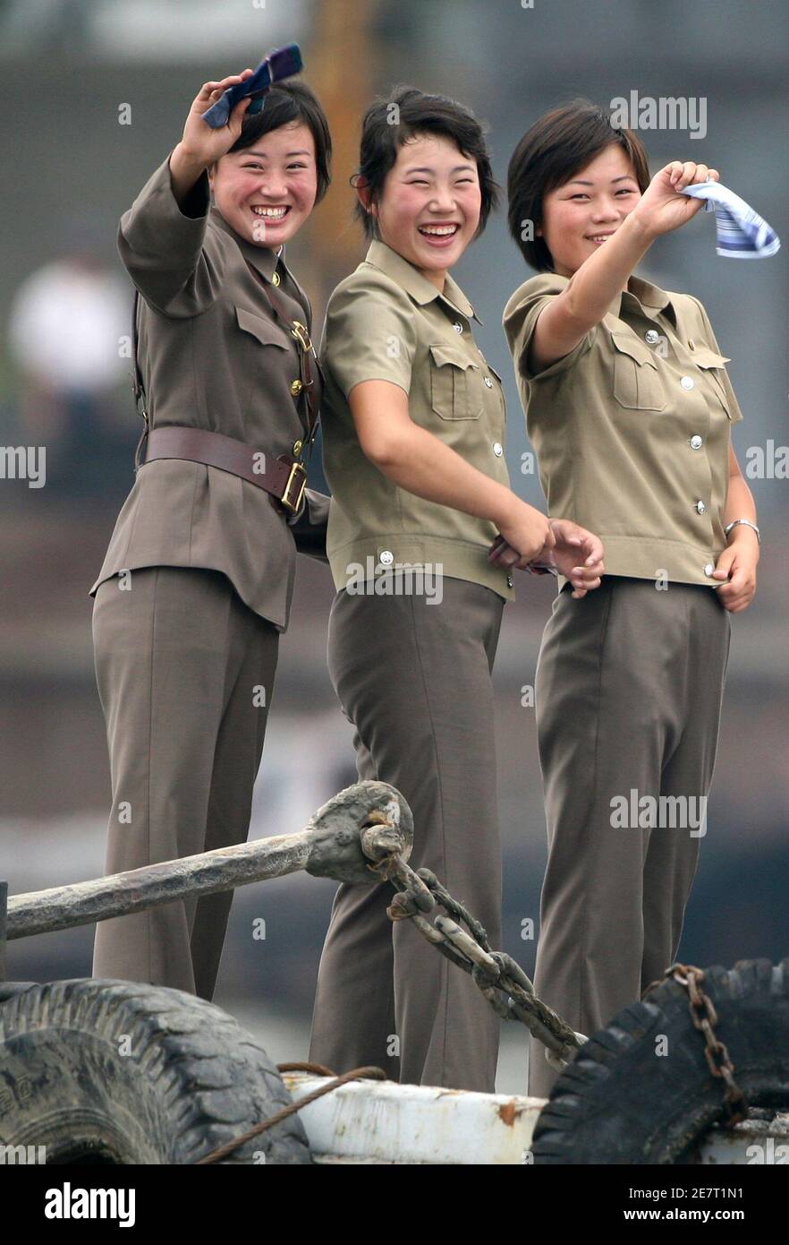 Female North Korean soldiers wave to a Chinese boat for tourists on the banks of Yalu River near the North Korean town of Sinuiju July 27, 2010. REUTERS/Jacky Chen (NORTH KOREA - Tags: MILITARY SOCIETY IMAGES OF THE DAY) Stock Photo