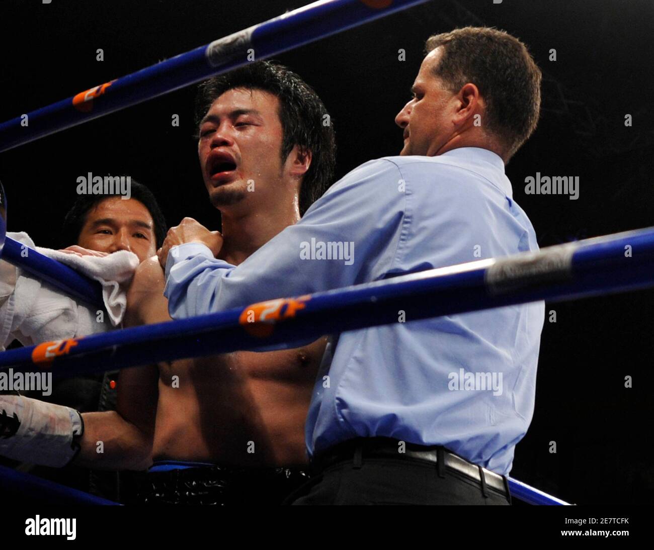 WBA referee Luis Pabon of Puerto Rico checks the condition of Japan's Koji Sato (C) before finishing Sato's WBA middleweight fight against Germany's Felix Sturm in the western German city of Krefeld near Duesseldorf April 25, 2009. Sturm beat Sato by technical knock-out in the seventh round. REUTERS/Wolfgang Rattay (GERMANY SPORT BOXING) Stock Photo