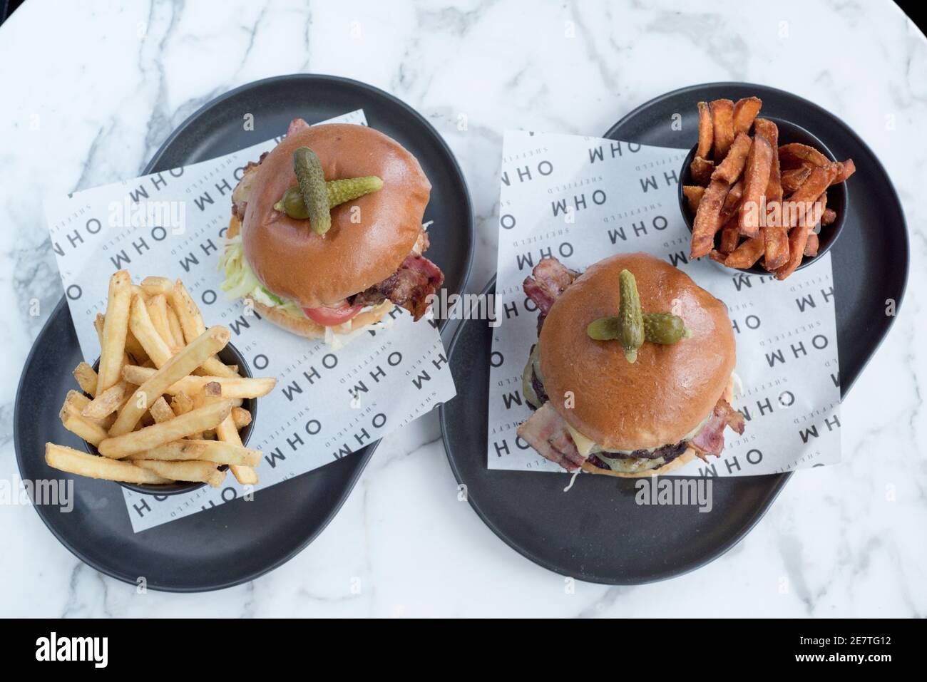 Sheffield, UK - 03 Aug 2017: Two burgers with sweet potato fries and chips at OHM, Fitzwilliam Street Stock Photo