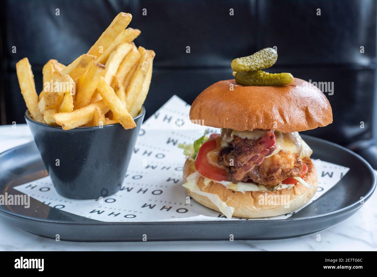 Sheffield, UK - 03 Aug 2017: Chicken cheese and bacon burger served with french fries at OHM, Fitzwilliam Street Stock Photo