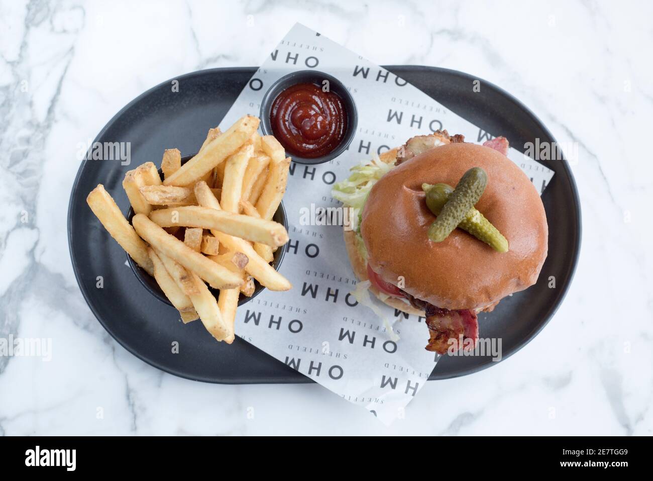 Sheffield, UK - 03 Aug 2017: Chicken cheese and bacon burger served with french fries at OHM, Fitzwilliam Street Stock Photo