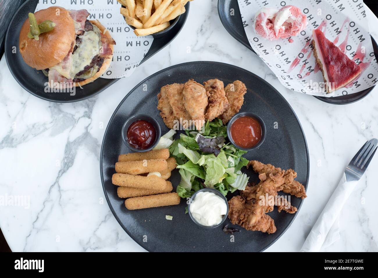 Sheffield, UK - 03 Aug 2017: Southern fried chicken, burger and fries, cheesecake and more American diner food at OHM, Fitzwilliam Street Stock Photo